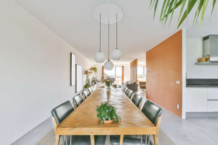 Magnificent large dining area with a long table and a vase of flowers