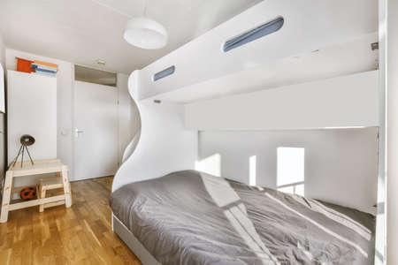 Cozy and stylish bedroom with a large bed covered with a gray bedspreadの写真素材