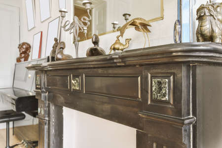 Cute shelf above the fireplace with many decorative souvenirsの写真素材