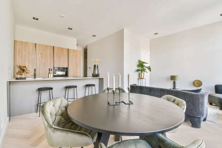 Stylish dining room with a round table and velvet chairs in a minimalist styleの写真素材