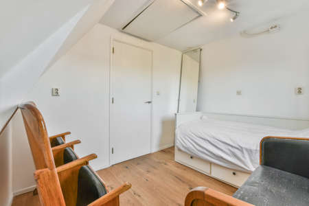 Bedroom with a single bed and dermal black sofa and armchairs