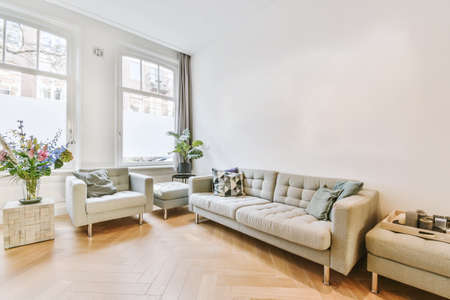 Amazing living room area with light sofa and large windows