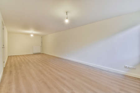 Interior of an empty room with wooden floor , white walls and turned on lamps