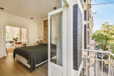 Lovely bedroom with a bed covered with a black blanketの写真素材