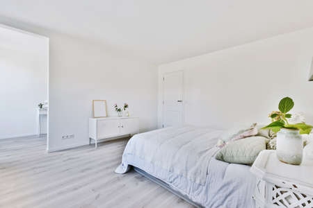 Stylish bedroom in minimalist style with parquet floor