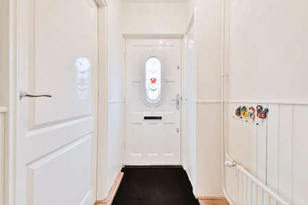 Modern entrance part of the house with a wooden door and a black rugの写真素材