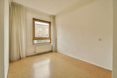 interior of an empty room with stylish curtain and a window