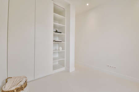 White wooden wardrobe and shelfes in an empty roomの写真素材