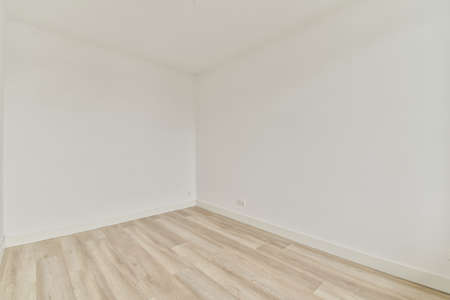 an empty room with white walls and wooden floor
