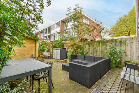a set of table,chairs,sofa and a bench in the garden of the houseの写真素材