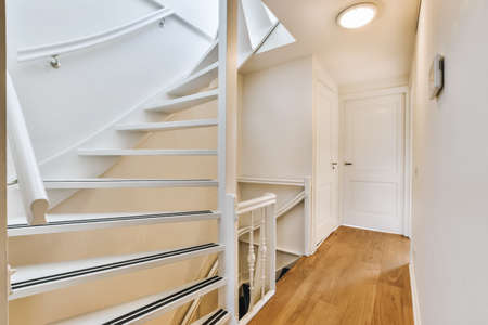 Cute hallway design with wooden stairs in daylight
