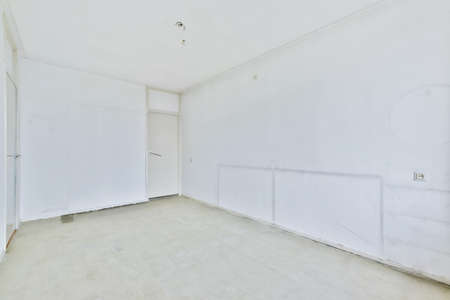 An empty and bright room with white walls and a door