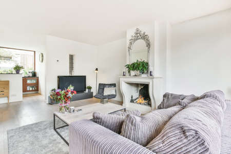 Spacious living room in Scandinavian style with a fireplace and upholstered furnitureの写真素材