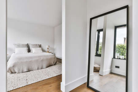 Stylish bedroom with a soft bed and parquet floorの写真素材