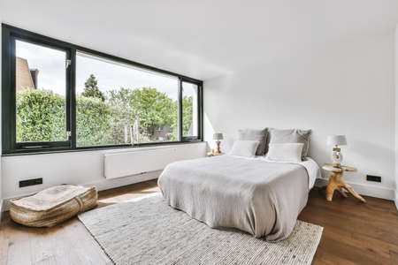 Stylish bedroom with a large window and a soft bed
