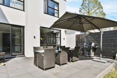 Wicker chairs and a black table in a minimalist style in the courtyard of the house