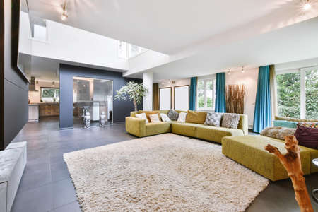 Cozy large living room with a yellow sofa in daylight