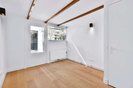 Stylish room in daylight with white walls and parquet floor