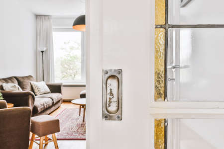 White door with living room in the background with brown sofa