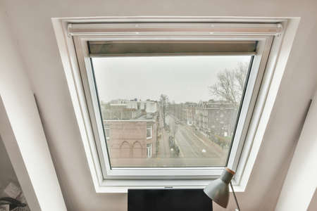 View from a small square window to the street and the city landscape in a modern house