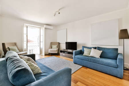 Luxurious living room design with blue sofa and beige armchair
