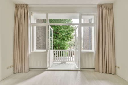 Access to a small balcony from a spacious room in a cozy house