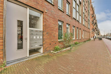 Entrance to a multi-storey residential building with a metal door and an intercom