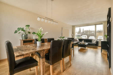 Spacious living room with black sofa dining area and panoramic window in a modern house