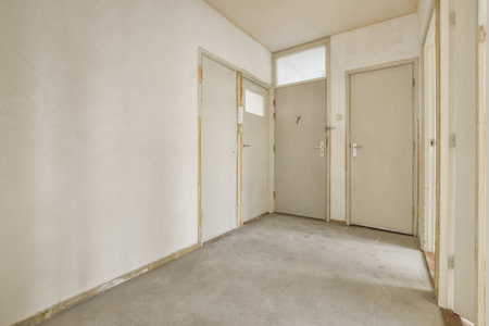 A small bright corridor with an entrance to several rooms in a small residential building
