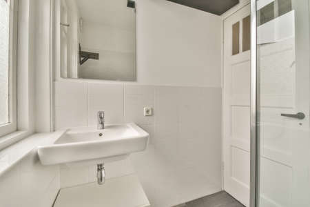 The interior of the bathroom in white of a modern house with sink and mirror