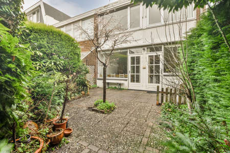 Cozy backyard with lots of plants and tiled floors at the modern cottageの写真素材