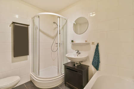 Bathroom in a modern design with shower, sink and bathtub in a traditional house