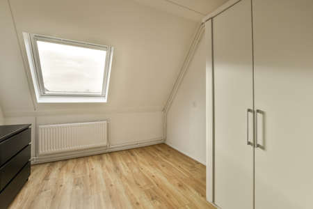 A small dressing room with several wardrobes on a parquet floor in a modern house