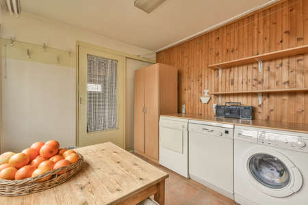 A small sitting area with wicker furniture next to the laundry room in a modern house