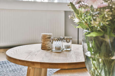 Decorations of a residential apartment with a round table and souvenirs on it as well as with...