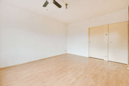 Interior of empty modern apartment with geometric design with entrance door and white walls and parquet floor illuminated with lampの写真素材