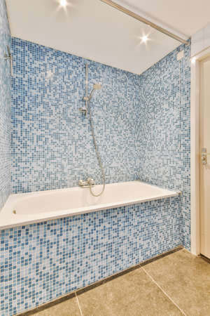 Small bedroom tiled with blue tiles in the form of a mosaic in a modern house