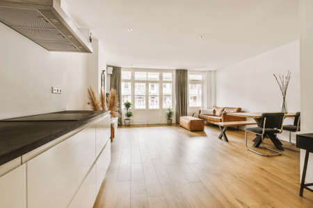 Side look to kitchen with bright light from window, table and sofa in the corner