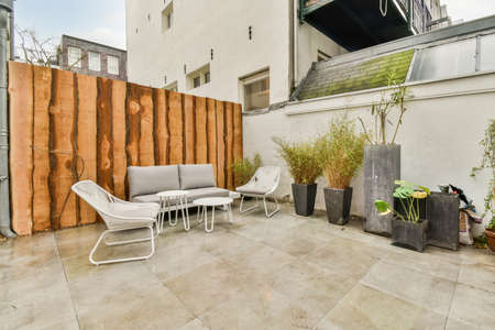 The interior of the backyard with a seating area on the marble floor and several indoor plants