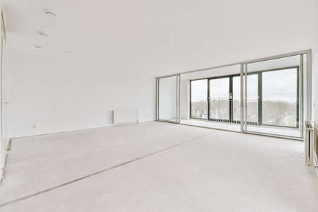Spacious, empty, bright room with access to a glazed balcony with panoramic windows in a modern houseの写真素材