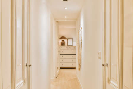 The interior of a spacious bright corridor in white tones in a modern residential apartmentの写真素材