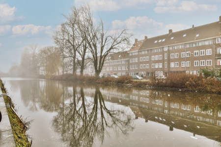 Lake and buildings in the misty weather photo from sideの写真素材
