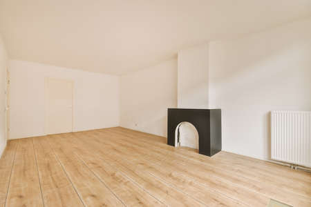 Interior of spacious light room with fireplace and elegant chandelier against balcony door and windowsの写真素材