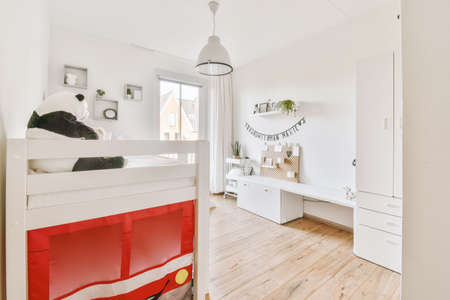 A small childrens room with a high bed in bright colors in a cozy modern house