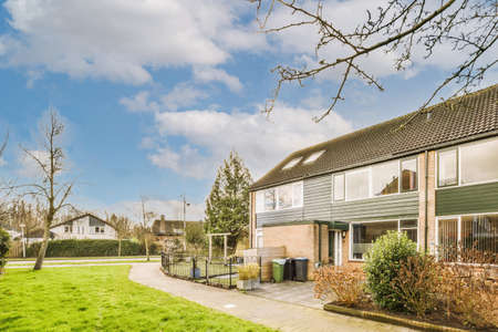 The front view of a brick building with signs,pavement and wooden doors lead to the apartmentの写真素材