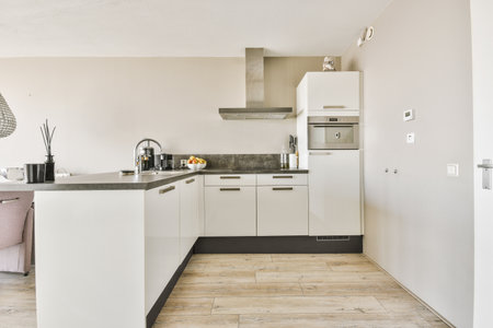 Interior of contemporary kitchen with stylish black cupboards and appliances near dining area in...
