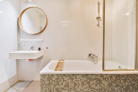 Interior of white tiled bathroom with circle mirror