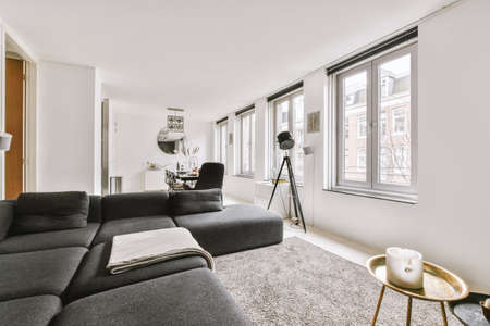 Bright dining-room with grey sofa,pillows next to the kitchen