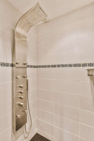 Modern shower cabinet with silver equipments and white tiled walls
