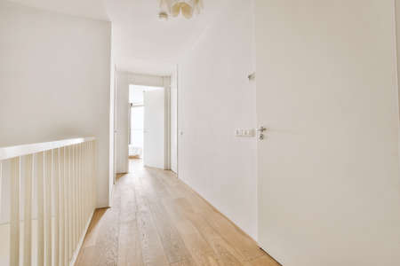 White opened door in a long white hall